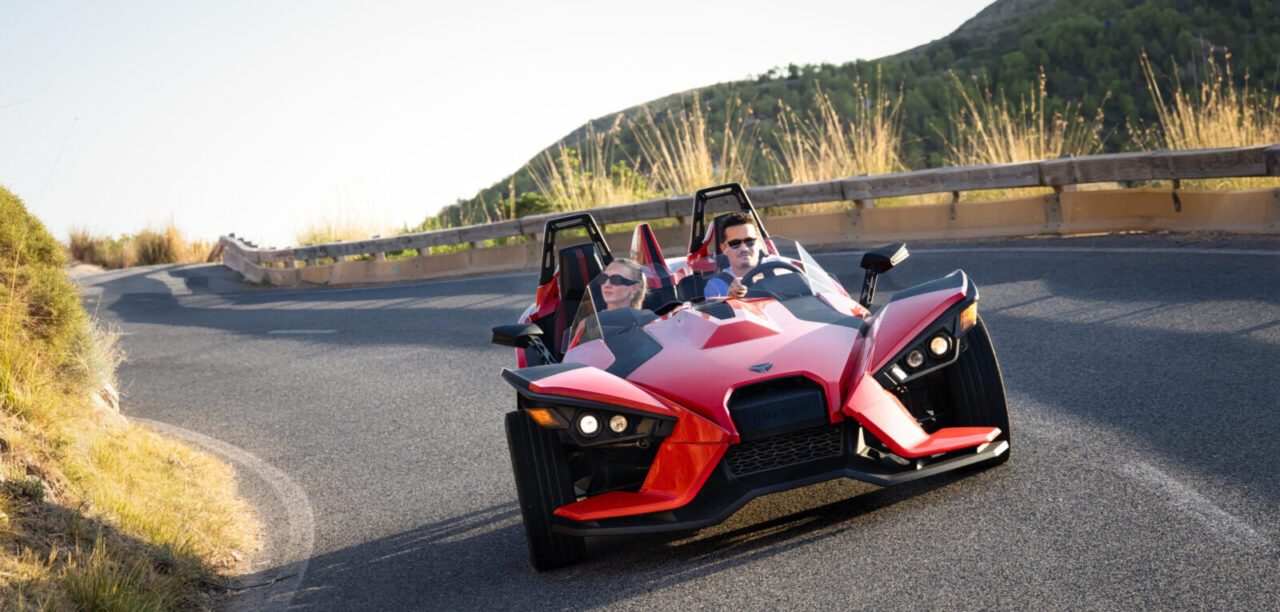 couple enjoying an island tour in mallorca in a Polaris slingshot vehicle.