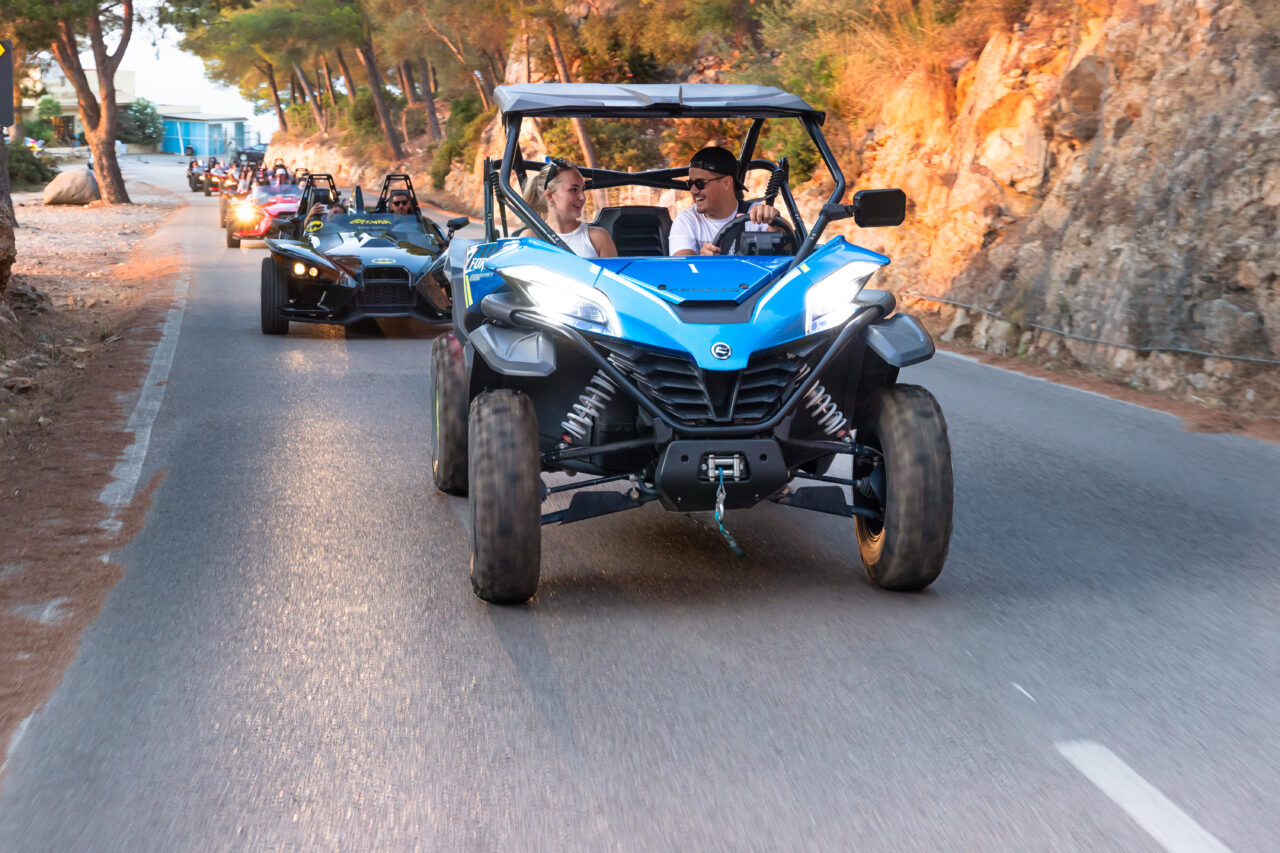 couple enjoying a buggy tour in mallorca followed by other buggy vehicles