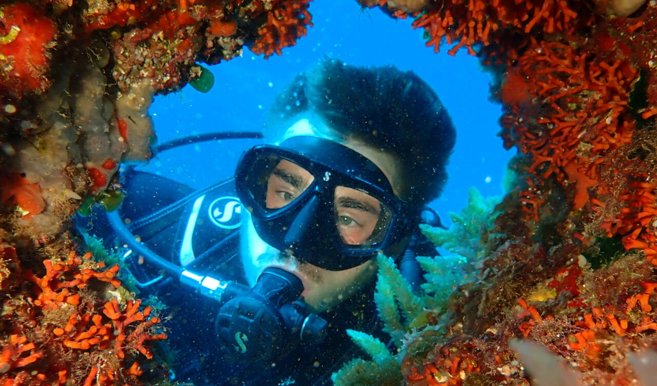man exploring an underwater cave during a scuba diving tour in mallorca