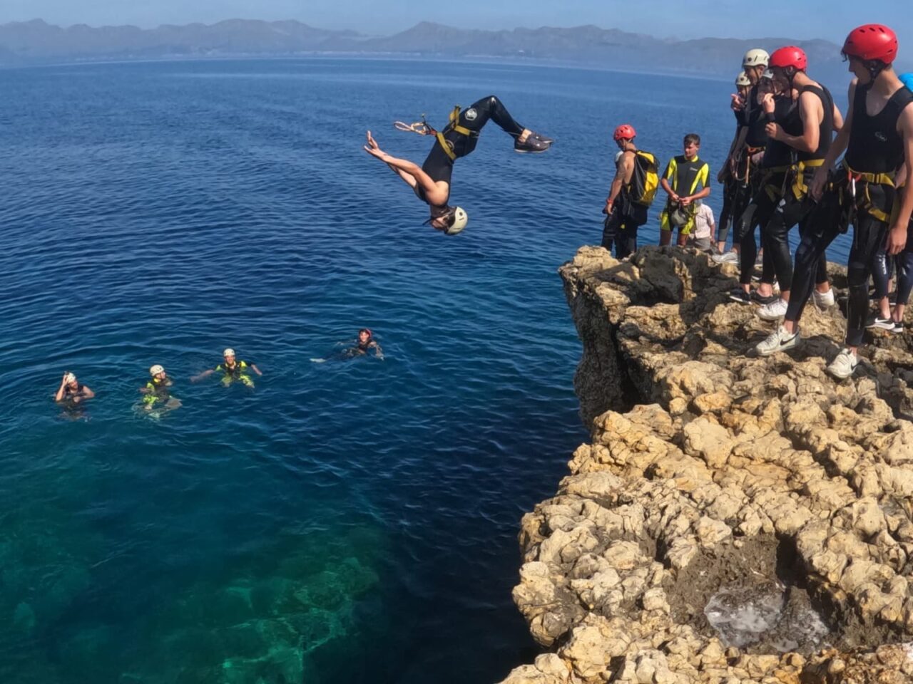 Rock climbing tour in Mallorca with climbers ascending a coastal cliff